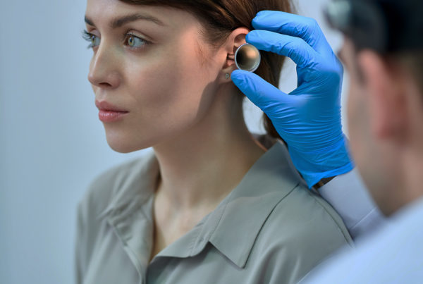 Female patient getting an ear examine by an audiologist